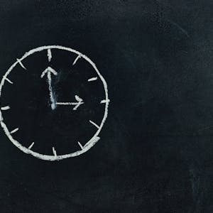 Chalk-drawn clock on a blackboard, symbolizing time and education concepts.